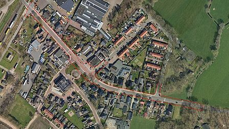 Luchtfoto van de Wolweg met daaromheen woningen, bedrijven, andere wegen en stukken grond.