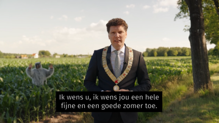 Burgemeester voor een veld met een zwaaiend wolfachtig figuur. Tekst: ik wens u ik wens jou een hele fijne en goede zomer toe