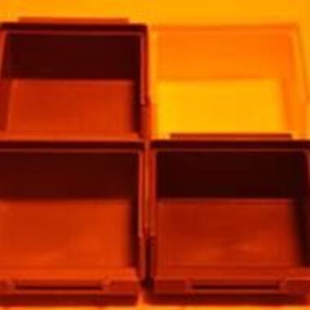 Gekleurde bakjes die verlicht worden met oranje licht, alles lijkt rood/oranje