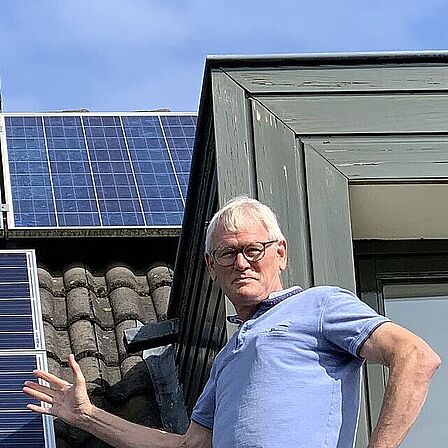 Energieambassadeur Ad van Rooijen op het dak bij zonnepanelen